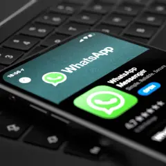 Smartfon z aplikacją WhatsApp na klawiaturze laptopa. Teraz możesz korzystać z WhatsApp na komputerze.