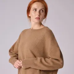 Kobieta w brązowym swetrze z wełny wielbłądziej.