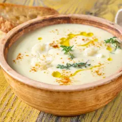 Un onctueux potage Dubarry, garni de chou-fleur, d'huile d'olive et de thym, servi avec des toasts grillés.