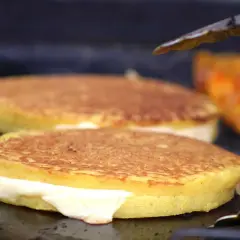 Arepas de choclo doradas y rellenas de queso derretido, listas para ser disfrutadas.