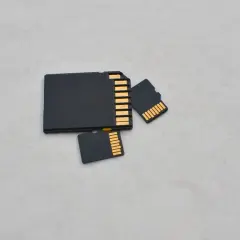 Porównanie rozmiarów: duża karta SD i dwie mniejsze karty microSD (TF). Różnica w wielkości jest oczywista.