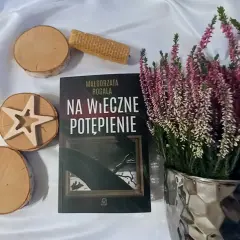 Małgorzata Rogala, cykl Monika Gniewosz: "Na wieczne potępienie" na tle wrzosów i drewnianych ozdób.