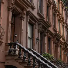 Brązowe kamienice w stylu brownstone, typowe dla Harlem, Nowy Jork, z ozdobnymi detalami i schodami.