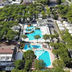 Malowniczy camping residence village z basenami, zjeżdżalniami i domkami wśród drzew. Idealne miejsce na wakacje.