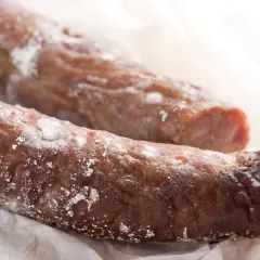 Na dwóch kiełbasach widać biały nalot, który może być oznaką pleśni.