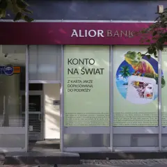 Alior Bank zaprasza na konto jakże osobiste z kartą dopasowaną do podróży. Reklama z jaszczurką i palmami.