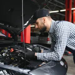 Mechanik w warsztacie sprawdza stan cewek zapłonowych w silniku samochodu.