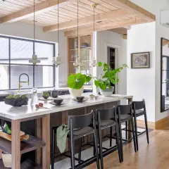 Nowoczesna kuchnia w stylu **styl modern farmhouse** z wyspą, marmurowym blatem, drewnianymi belkami i dużą ilością zieleni.