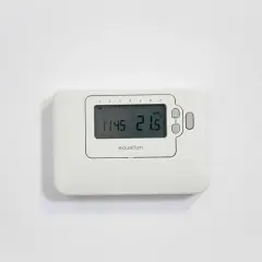 Termostato Equation en pared blanca. Muestra la hora 11:45 y la temperatura 21.5°C. Ideal para cambiar el termostato de calefacción.