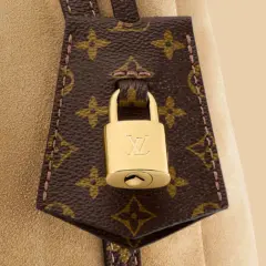 Złota kłódka z logo LV na brązowej skórze z monogramem Louis Vuitton.