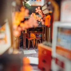Miniaturowy japoński zaułek z dwoma stołkami, idealny do stworzenia własnego **diy book nook**.