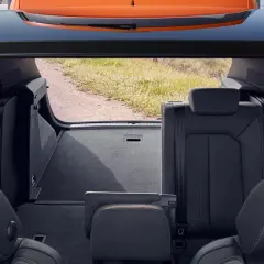 Widok z bagażnika na tylne siedzenia i otwartą klapę. Wnętrze Audi Q3 gotowe na podróż.