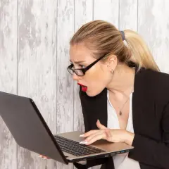 Zaskoczona kobieta w okularach szuka w internecie, gdzie sprawdzić L4.