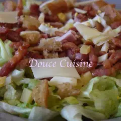 Salade savoyarde généreuse avec lardons, fromage, œuf dur et croûtons. Un délice pour les papilles.