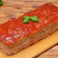 Pyszna pieczeń z mięsa mielonego na kanapki, polana sosem pomidorowym i ozdobiona listkami bazylii. Idealna na rodzinny obiad lub jako dodatek do kanapek.