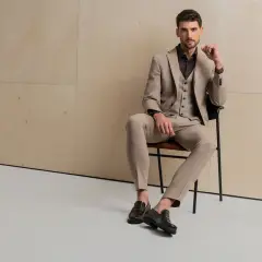 Elegancki mężczyzna w beżowym garniturze i kamizelce, idealny wybór, jaki garnitur dla blondyna.