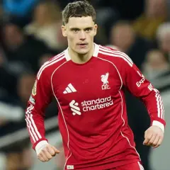 Piłkarz Liverpoolu w czerwonej koszulce, gotowy do gry. Jego determinacja może wpłynąć na rankingi Liverpoolu.