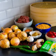 Ingredienser för afghansk mantu: köttfärs, lök, vitlök, ingefära, chili, tomatpuré, gula linser, kryddor och wonton-deg.