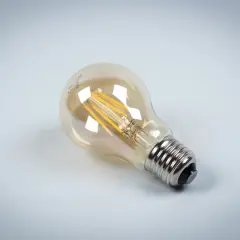 Szklana bańka żarówki LED z widocznymi drucikami, osadzona na metalowym gwincie.