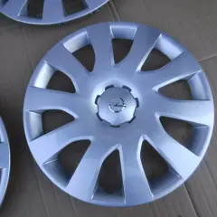 Srebrne kołpaki Opel Vivaro z logo marki. Komplet czterech sztuk, idealny do odświeżenia wyglądu Twojego auta.