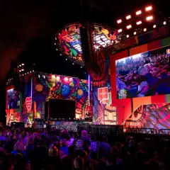 Kolorowa scena festiwalu Pol'and'Rock z wielkim ekranem wyświetlającym tłum i artystów.