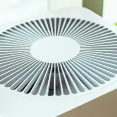 Purificador de aire blanco con rejilla circular. Considera las contraindicaciones del purificador de aire para un uso seguro y efectivo.