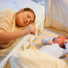 Mamma dorme accanto al lettino dove un bambino di 2 anni si sveglia piangendo disperato.