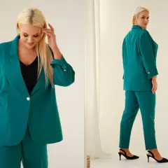 Elegancki, zielony garnitur damski na wesele dla puszystych. Model z marynarką i spodniami, idealny na specjalne okazje.