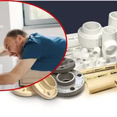 Hydraulik naprawia zlew, a obok leżą różne elementy instalacyjne: kolanka, trójniki, zawory i rura.