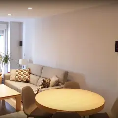 Salón moderno con sofá beige, mesa de centro y mesa redonda. El **IP40 significado** se refleja en la iluminación empotrada y el diseño funcional.