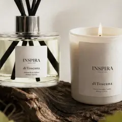 Dyfuzor i świeca Inspira "di Toscana" na tle drewna. Te zapachy tworzą własne, piękne histoires de parfums.