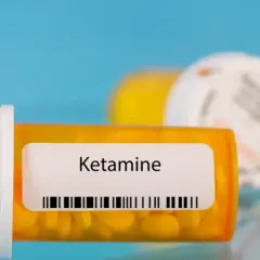 Lek ketamina co to? Pomarańczowa buteleczka z tabletkami i etykietą "Ketamine".