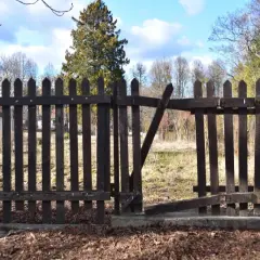 Drewniane ogrodzenie między sąsiadami, z otwartą furtką. Czy przepisy pozwalają na takie rozwiązania?