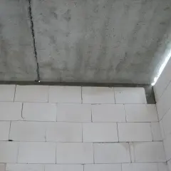 Betonowy strop dz 3 z widocznym pęknięciem, nad ścianą z białych pustaków.