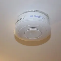 Ein weißer Rauchmelder hängt an der Decke. Er scheint von alleine auszugehen, da kein Alarm zu hören ist.