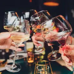 Ludzie wznoszą toasty kieliszkami z winem. Czy 5-HTP i alkohol to dobre połączenie?