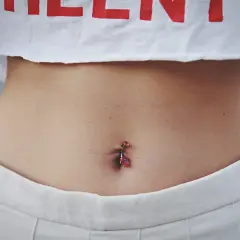 Cena kolczyka w pępku zależy od salonu i materiału. Ten z czerwonymi kamieniami wygląda na modny.