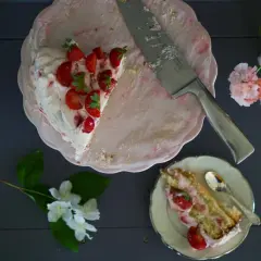 En bit av en läcker jordgubbstårta med grädde och färska jordgubbar. Ett perfekt jordgubbstårta recept för sommaren.