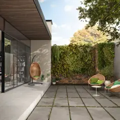 Nowoczesny taras ogrodowy inspiracje: wiszący fotel, plecione fotele i zielona ściana.