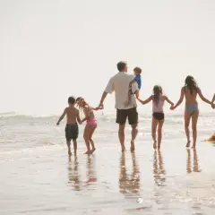 Rodzina z psem na plaży, idealna na kartę dużej rodziny dla kogoś, kto ceni wspólne chwile.