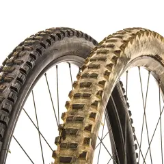 Two mountain bike tires, one new and one worn, illustrate when to replace mountain bike tires.
