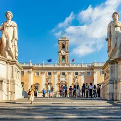 Devant les musées du Capitole, des statues équestres majestueuses encadrent une foule admirative.