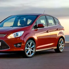 Röd Ford C-Max parkerad vid havet. Inga problem här, bara en vacker vy.