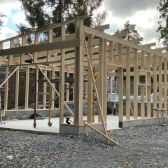 Trästomme till ett garage under uppbyggnad. Grunden är gjuten och stommen reses, vilket ger en bra uppfattning om bygga garage kostnad.
