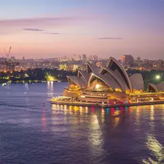 Zachód słońca nad Operą w Sydney. Marzenie o wizie do Australii staje się rzeczywistością, gdy miasto rozświetla się nocą.