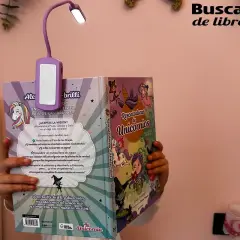 Una lampara brazo articulado ilumina un libro de unicornios.