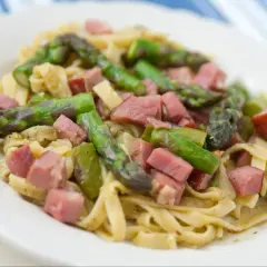 Pyszny makaron ze szparagami i kawałkami szynki, danie pełne wiosennych smaków.