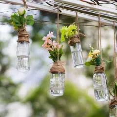 Upcycling ideen gartendeko selber machen: Hängende Glasflaschen mit Blumen als romantische Deko.