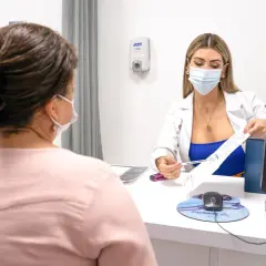 Médica explica tratamiento para la acidez en la boca a paciente.