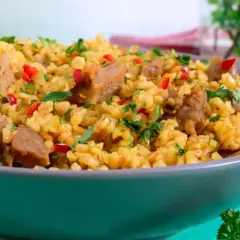 Pyszne kaszotto z kurczakiem, papryką i natką pietruszki, podane w szarej misce.